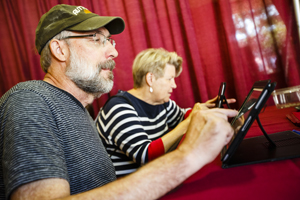 A man and a woman using iPad tablets.