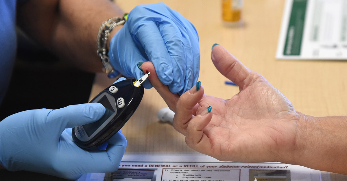A woman getting her finger pricked for a blood glucose check.