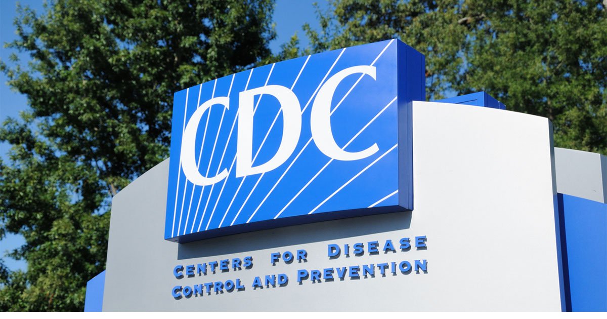 Blue sign on gray background that says CDC Centers for Disease Control and Prevention