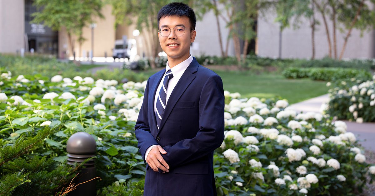 Erjia Cui standing outside in a blue suit
